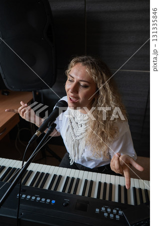 Caucasian woman singing into microphone and recording herself on laptop.  131335846