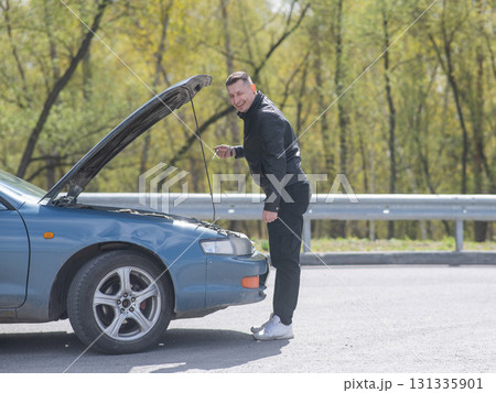Caucasian man checking engine oil level in his car.  131335901