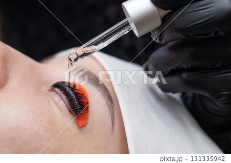 The process of professional lamination and tinting of eyelashes in the salon. 131335942