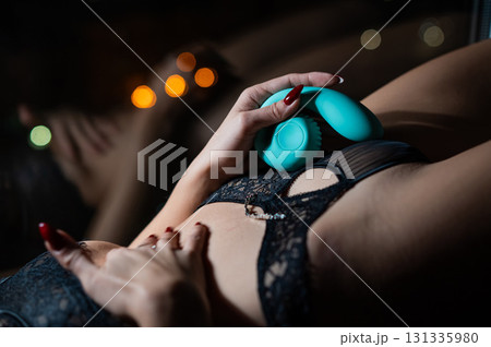 Woman uses blue curved vibrator. Woman uses blue curved vibrator. 131335980