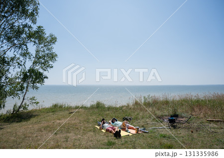 Caucasian couple relaxing during a hike on the seashore. Caucasian couple relaxing during a hike on the seashore. 131335986