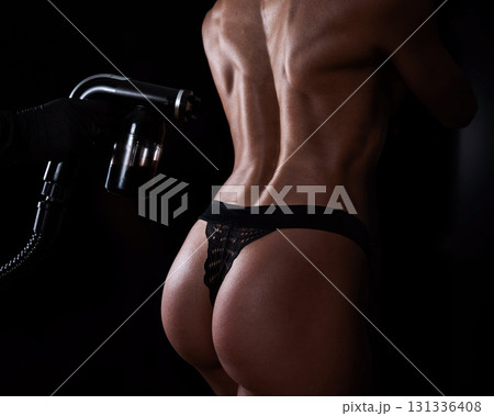 The master applies tinting paint on the back of a woman. Instant tanning treatment. The master applies tinting paint on the back of a woman. Instant tanning treatment. 131336408