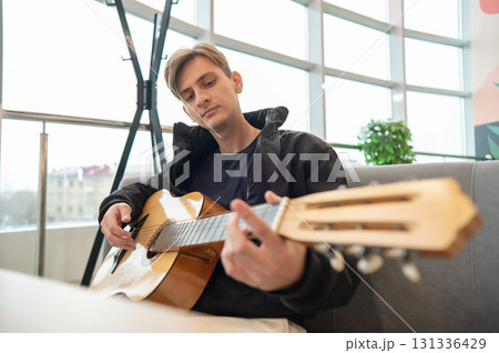 Caucasian man sitting in cafe and playing guitar. Caucasian man sitting in cafe and playing guitar. 131336429