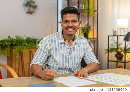 Indian man finds correct contract signs with pen smiles confident about decision result success win Indian man finds correct contract signs with pen smiles confident about decision result success win 131336430