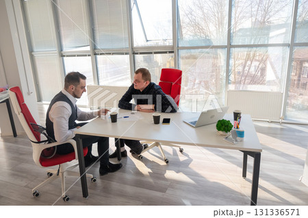 Two Caucasian men negotiating in an office. Two Caucasian men negotiating in an office. 131336571