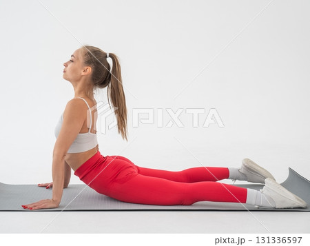 Young woman doing cobra exercises on white background. 131336597