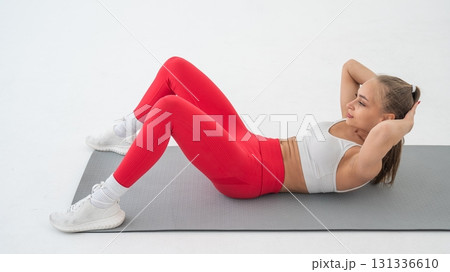 Young woman doing abdominal exercises on white background. 131336610