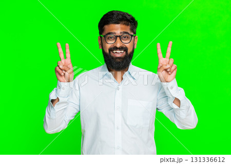 Indian man showing V sign with fingers smiling expressing victory peace positive gesture chroma key 131336612
