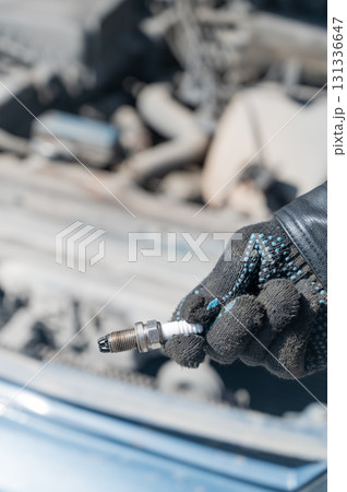Caucasian man changing spark plugs in car. Caucasian man changing spark plugs in car. 131336647