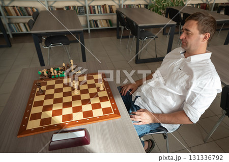 Middle aged Caucasian man playing chess.  131336792