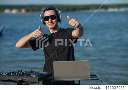 Caucasian man works as a DJ on the beach. Caucasian man works as a DJ on the beach. 131337055
