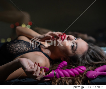 Beautiful brunette in lace lingerie holds pink dildo. Beautiful brunette in lace lingerie holds pink dildo. 131337093