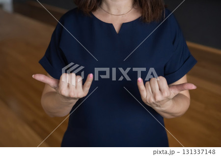 A woman shows the word today in Russian sign language. A woman shows the word today in Russian sign language. 131337148