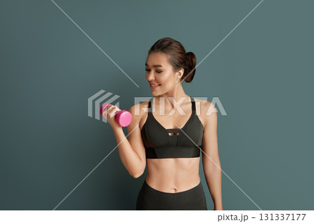 Fitness workout. Woman lifting dumbbell weights for strength training. 131337177