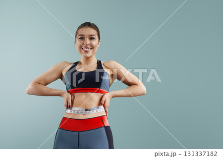 Weight loss, slim body, healthy lifestyle concept. Fit fitness girl measuring her waistline with measure tape. Weight loss, slim body, healthy lifestyle concept. Fit fitness girl measuring her waistline with measure tape. 131337182
