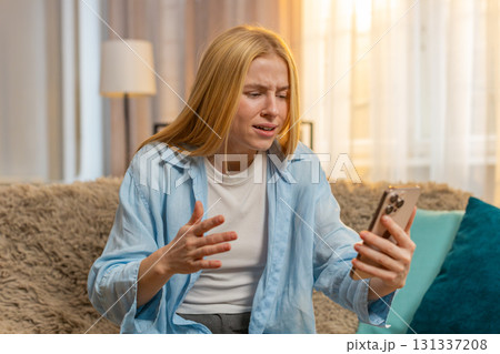 Young woman upset by phone fail, negative message, sudden meltdown, home sadness, deep frustration Young woman upset by phone fail, negative message, sudden meltdown, home sadness, deep frustration 131337208