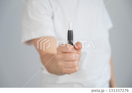 Faceless woman holding tobacco heating system.  131337276