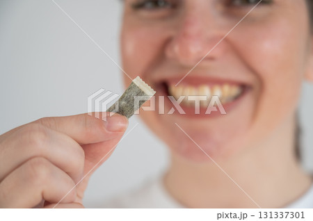 Woman Chewing Nicotine Snus Product.  131337301