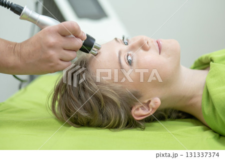 Caucasian woman undergoing radio wave RF lifting procedure in beauty salon.  131337374