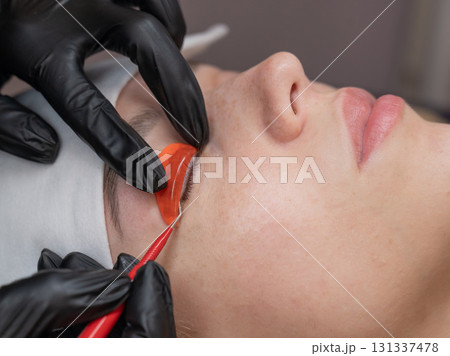 Caucasian woman undergoing eyelash lamination procedure.  131337478