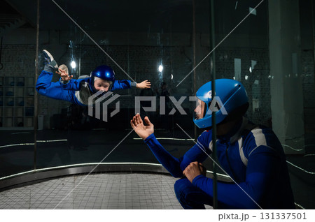 A man teaches a boy to fly in a wind tunnel. Lack of gravity. 131337501