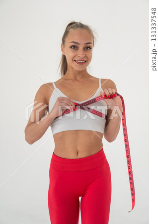 Young woman measuring her chest circumference on white background. 131337548