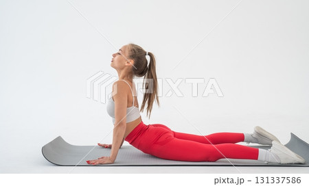 Young woman doing cobra exercises on white background. Young woman doing cobra exercises on white background. 131337586