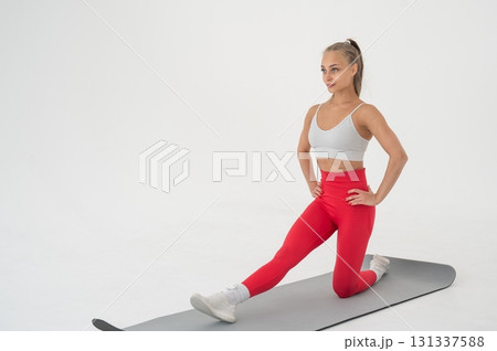 Young woman doing splits exercises on white background. Young woman doing splits exercises on white background. 131337588