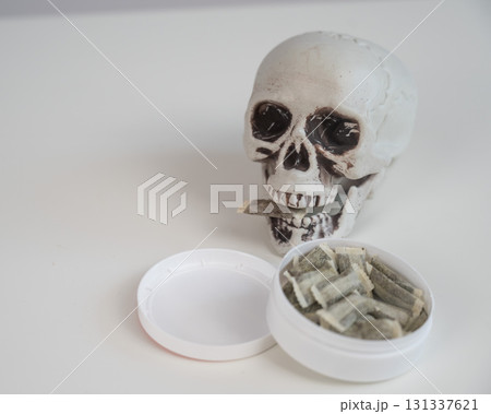 Skull Chewing Tobacco on a White Table. Skull Chewing Tobacco on a White Table. 131337621