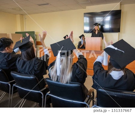 A young woman stands at the lectern and delivers a graduation speech to her classmates. A young woman stands at the lectern and delivers a graduation speech to her classmates. 131337667