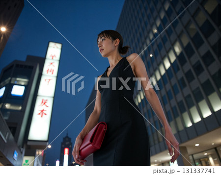 夜の都会を歩く女性とネオンの街並み 131337741