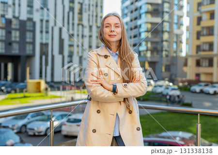 Portrait of happy blonde mature woman looking at camera standing arms crossed on city urban street Portrait of happy blonde mature woman looking at camera standing arms crossed on city urban street 131338138