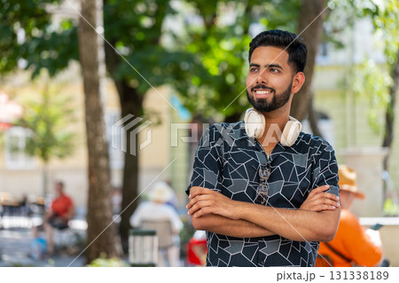 Portrait of happy Indian man smiling friendly, glad expression looking at camera with headphones 131338189