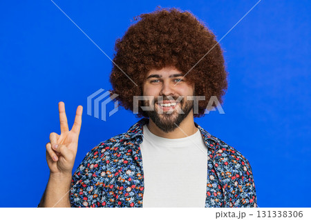 Happy smiling Caucasian man showing victory sign, hoping for success and win, doing peace gesture Happy smiling Caucasian man showing victory sign, hoping for success and win, doing peace gesture 131338306
