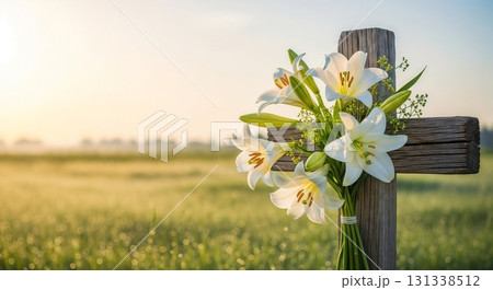 A wooden cross decorated with white lilies in a field. A wooden cross decorated with white lilies in a field. 131338512
