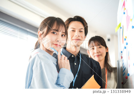 ホワイトボードを使って打合せする3人の男女 ホワイトボードを使って打合せする3人の男女 131338949