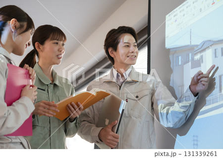 スクリーンの前で宅地開発の打ち合わせをする3人の男女のエンジニア 131339261