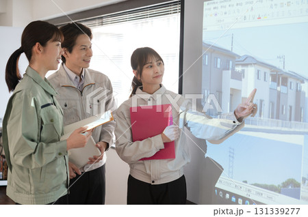 スクリーンの前で宅地開発の打ち合わせをする3人の男女のエンジニア スクリーンの前で宅地開発の打ち合わせをする3人の男女のエンジニア 131339277
