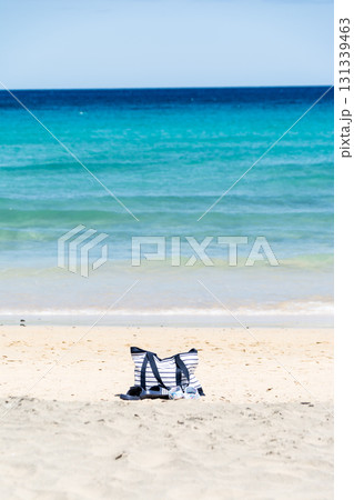 深い青とエメラルドグリーンの海岸の白い砂浜に置かれたバッグ　カナリア諸島のフエルテベンテュラ島にて 131339463