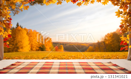Cozy blanket on grass under colorful autumn trees at sunset 131341021