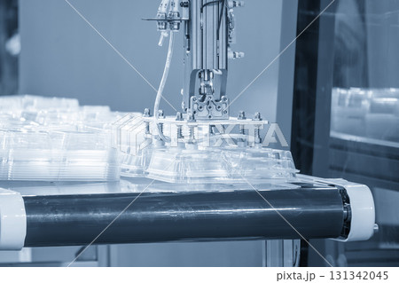 The food container production process by automatic system from plastic injection mold machine in the blue scene. The food container production process by automatic system from plastic injection mold machine in the blue scene. 131342045