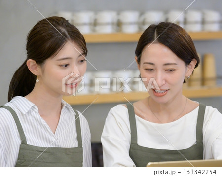 カフェの受付に並んでたつ女性スタッフ 131342254