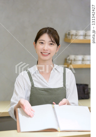 カフェで案内をする女性スタッフ 131342427