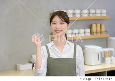 ガッツポーズをする女性スタッフ 131342647