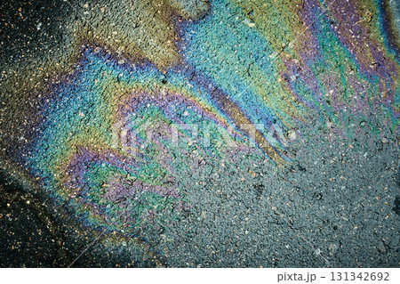 Oil slick on asphalt creating a colorful psychedelic rainbow pattern of iridescent sheen 131342692