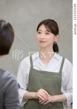 女性客と会話をするスタッフ 131343189