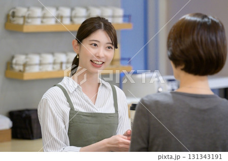 女性客と会話をするスタッフ 131343191