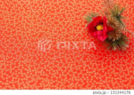 金色の花柄が入った赤い和紙と椿 131344176