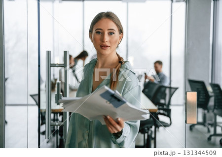 Female manager is with documents. Team of office workers are together indoors Female manager is with documents. Team of office workers are together indoors 131344509
