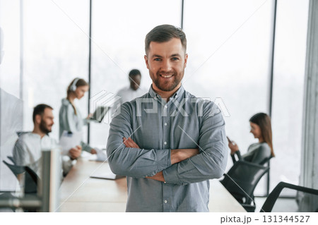 Handsome man with documents. Team of office workers are together indoors 131344527